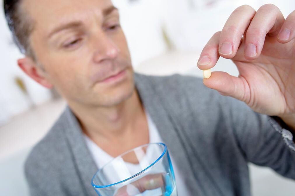 ein Mann trinkt eine Pille, um die Potenz zu steigern